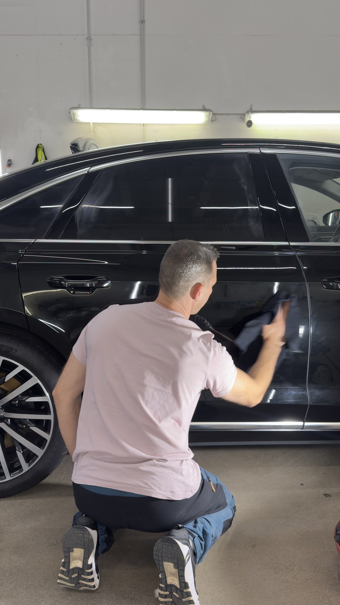 Poleerimisjääkide eemaldamine mikrofiiberrätiga Audi A8 tagaukselt