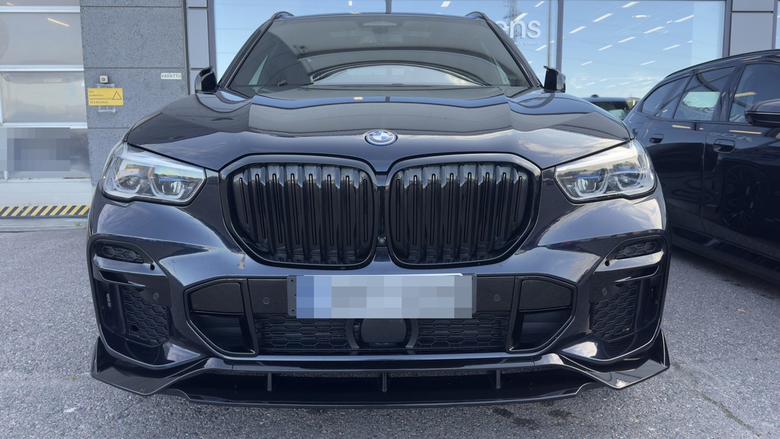 Musta BMW X5 esiots otsevaates pärast pesu ja katte uuendust, must pind on ühtlane ja läikiv